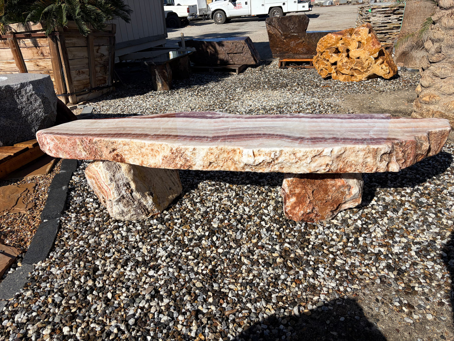 Natural onyx stone bench with unique color variations and polished surface for outdoor gardens and landscaping.