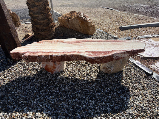 Natural onyx stone bench with unique color variations and polished surface for outdoor gardens and landscaping.