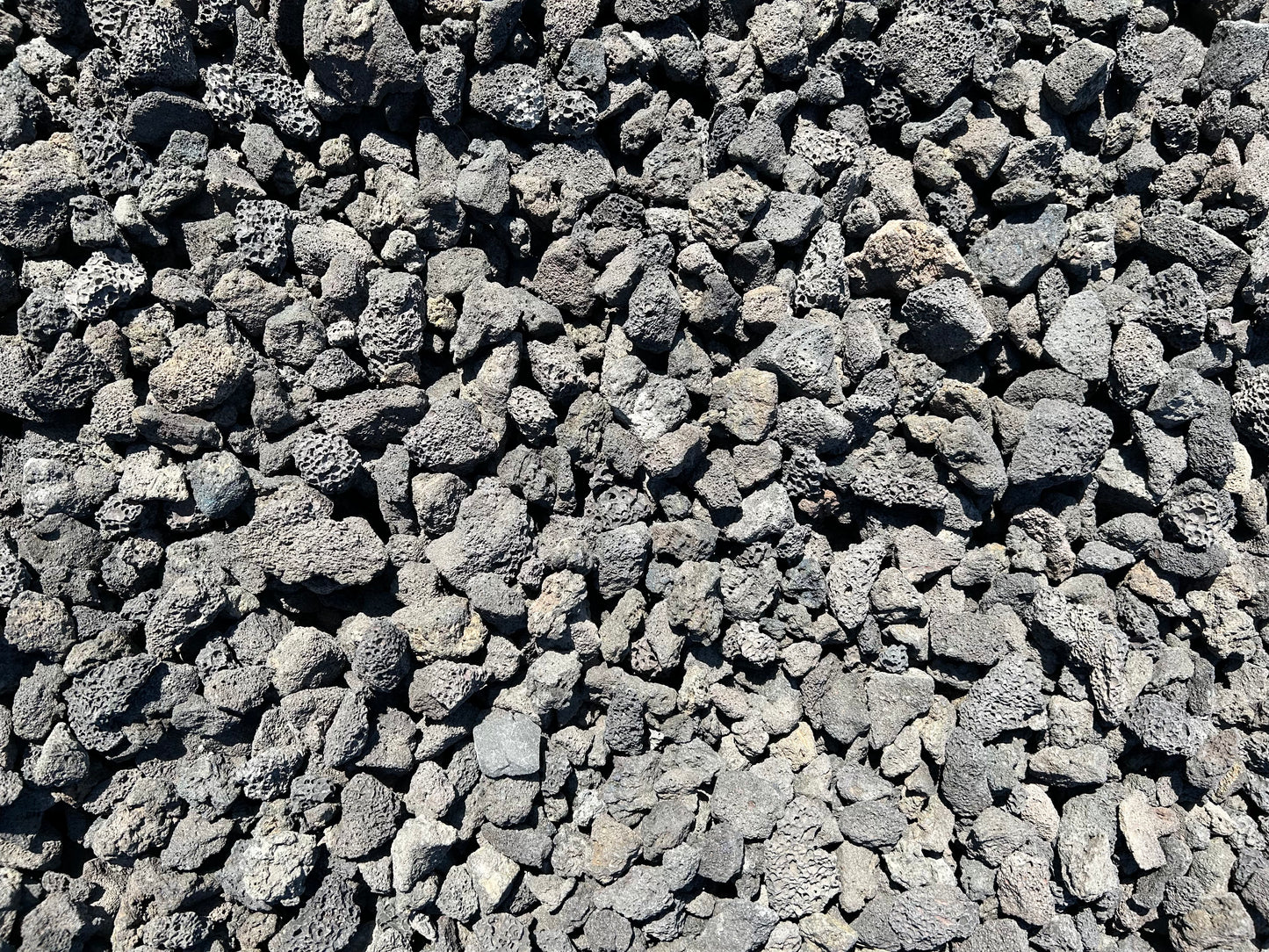 Black lava rock cinders with porous charcoal-black texture