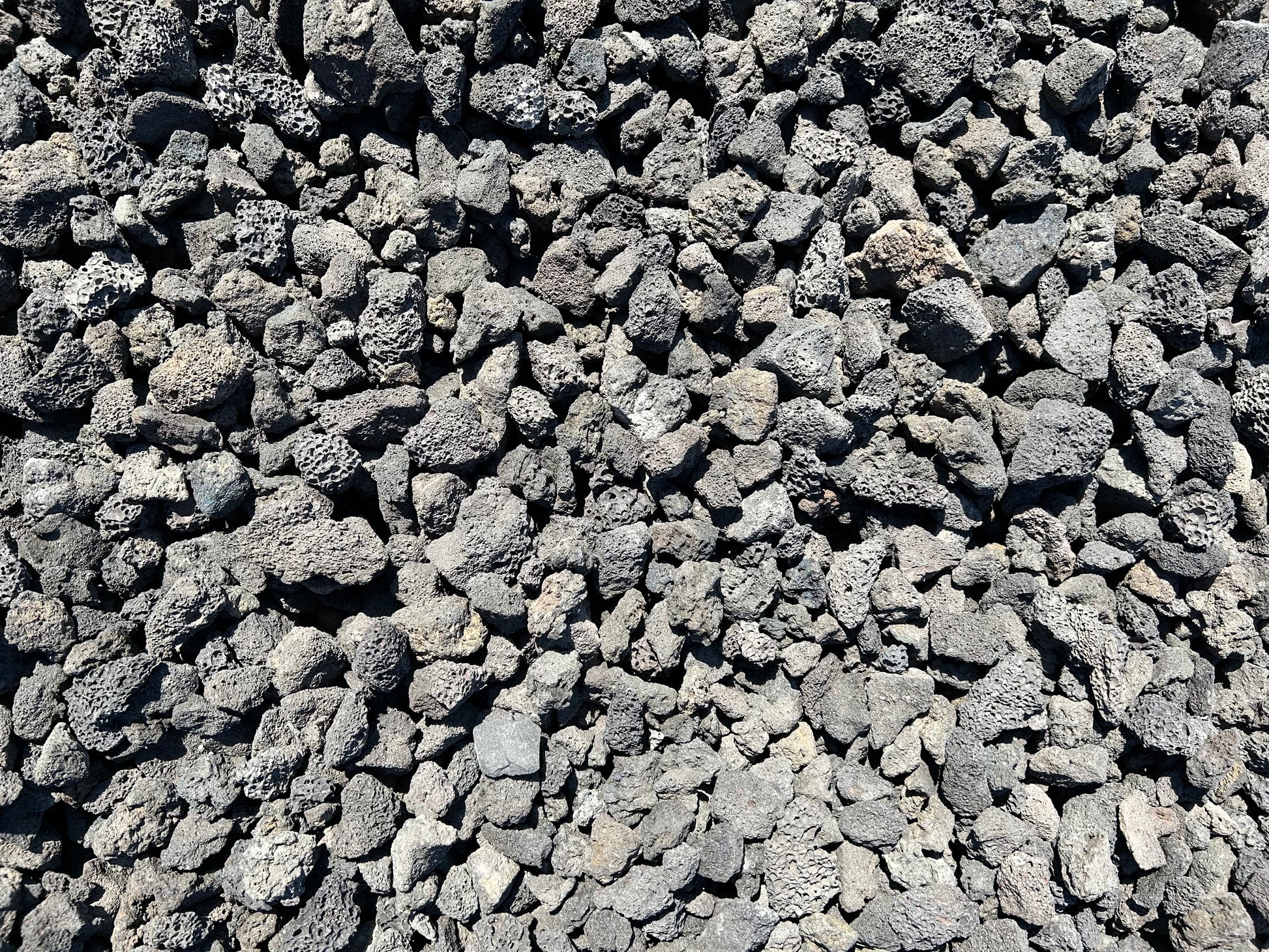 Black lava rock cinders with porous charcoal-black texture